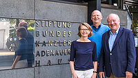 Vorstandsmitglieder (eine Frau und zwei M&auml;nner) vor dem Stiftungsgeb&auml;ude
